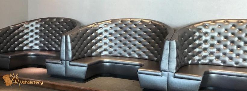 Sofa in yellow against a tiled wall — upholstered by M&M Upholstery, Dallas